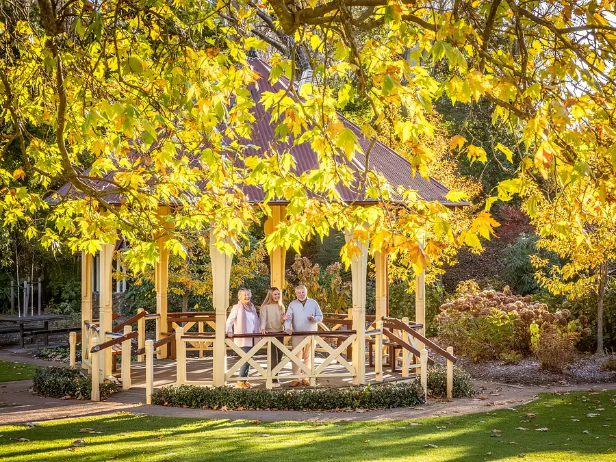 Family at the Leighton Gardens gazebo in autumn